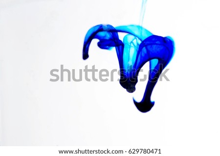 Color drop photographed in motion. Ink swirling in water isolated on white background.