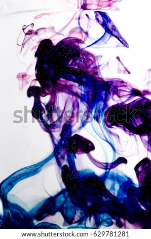 Colors dropped into liquid and photographed while in motion. Cloud of silky ink in water on white isolated background, an abstract banner.