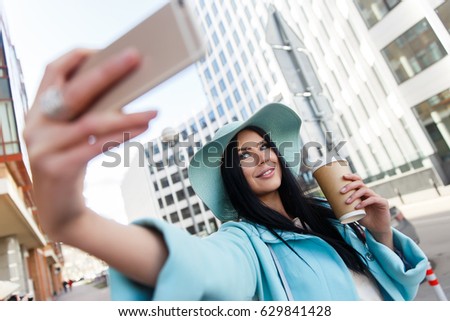 Brunette in hat takes pictures