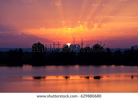 sunset near the lake on the background of the city