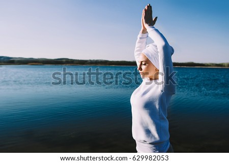 A young woman in white clothes doing yoga at the lake in the summer
 Royalty-Free Stock Photo #629982053