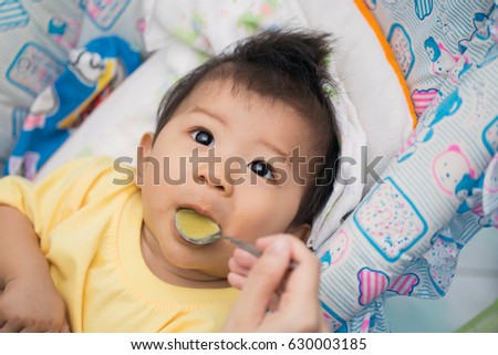 Beautiful baby eating mashed
