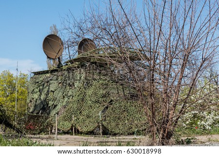 Air defense missile system of military mobile system of green launch vehicle, modern army industry,  sky against background. Military radar, antenna is disguised as combat position. Satellite antenna