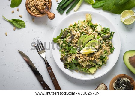 Fresh quinoa salad with spinach, avocado, seeds and Pine nuts. Clean eating detox and vegetarian food. Top view.