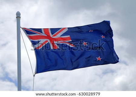 New Zealand flag, flying against the sky in windy conditions