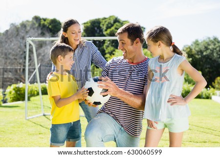 Happy family playing football together at the park