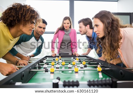 Executives playing table football in office Royalty-Free Stock Photo #630161120