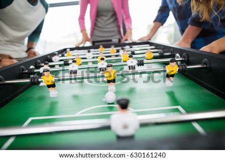 Mid section of executives playing table football in office Royalty-Free Stock Photo #630161240