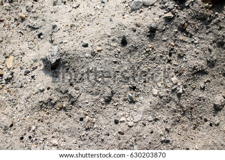 Detail of a wet sandy beach with smooth pebbles at soft lighting