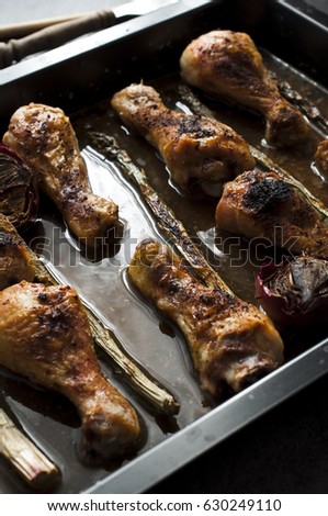 moody picture of grilled chicken legs with asparagus