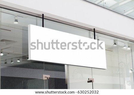 horizontal white empty signage on clothes shop front with glass windows  Royalty-Free Stock Photo #630252032