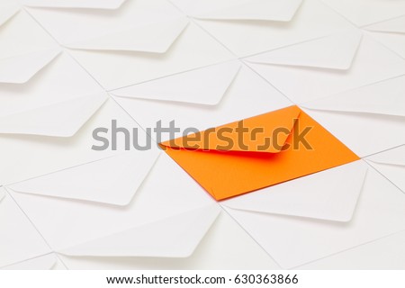 Composition with white envelopes and one orange envelope on the table.