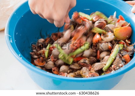 Motion picture of hand mixing with a mixture of spicy scallops salad.