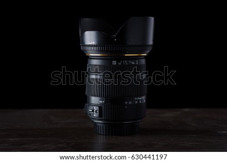 close up photo of camera lens on wood table with black background. Lens for camera.