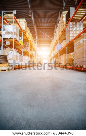 Warehouse industrial and logistics companies. Long shelves with a variety of boxes and containers. Toning the image. Bright sunlight. Royalty-Free Stock Photo #630444398