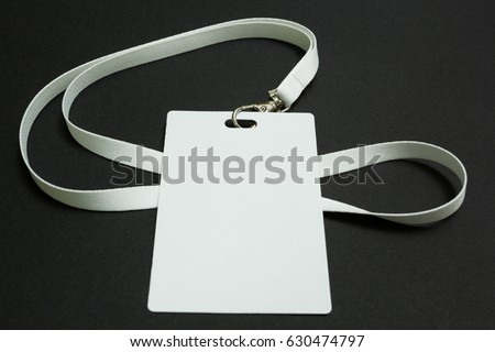 Blank badge mockup isolated on black. Plain empty name tag mock up hanging on neck with string.