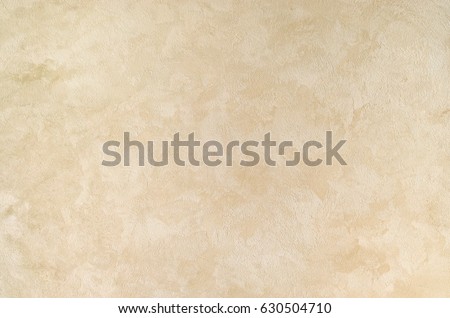 Textured background. Decorative plaster walls, external decoration of facade. Texture of beige. Royalty-Free Stock Photo #630504710