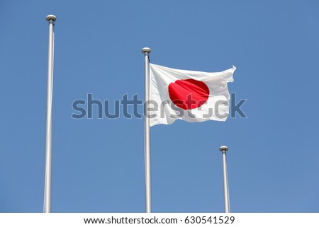 Japanese flag in wind against clear blue sky 