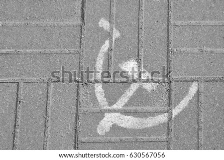 The hammer and sickle symbol of the Soviet Union on the pavement slab
