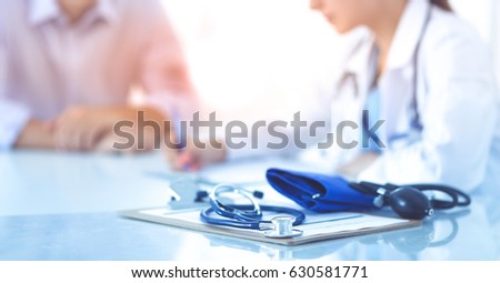Doctor woman sitting with  male patient at the desk Royalty-Free Stock Photo #630581771