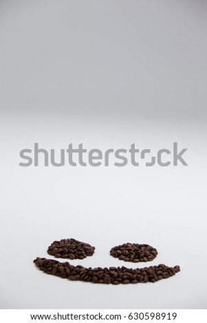 Coffee beans forming smiley on white background