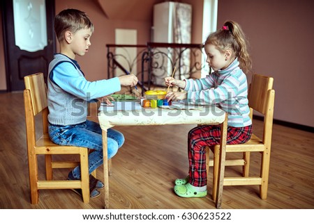 Children in nursery sitting at table drawing pictures