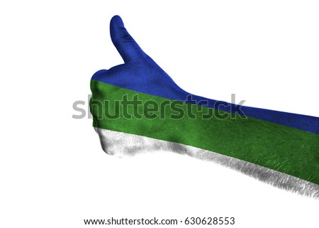 Hand making thumbs up sign. Komi painted with flag as symbol of thumbs like,up,okay. Isolated on white background.