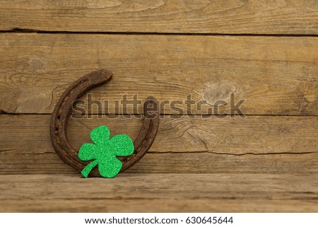 St Patricks Day shamrock with horseshoe on wooden surface
