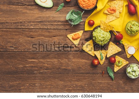 Fresh ingredients for homemade guacamole (avocado, tomato, salt) on wooden background. top view. Healthy food background with space for text.