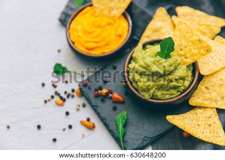nachos with guacamole on a gray background.