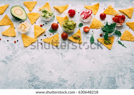 Avocado guacamole with fresh ingredients on wooden table