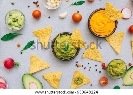 Guacamole bowl with fresh ingredients and tortilla chips on a vintage table. Top view. Flat lay 