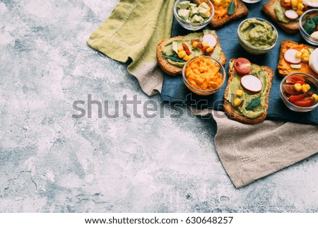 Traditional latinamerican mexican sauce guacamole with ingredients on dark background.