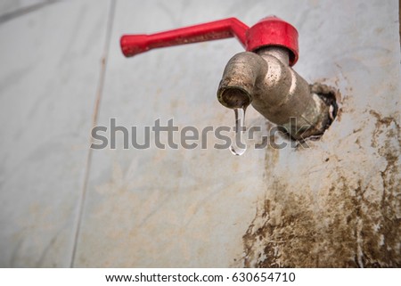 water leak out from red cap water tap in dirty washroom, selective focus Royalty-Free Stock Photo #630654710