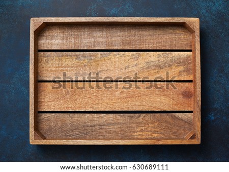Empty wooden box on blue background. View from above. Copy space Royalty-Free Stock Photo #630689111