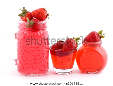 Jelly strawberry stands on a table in a pot near the paraphernalia and strawberry