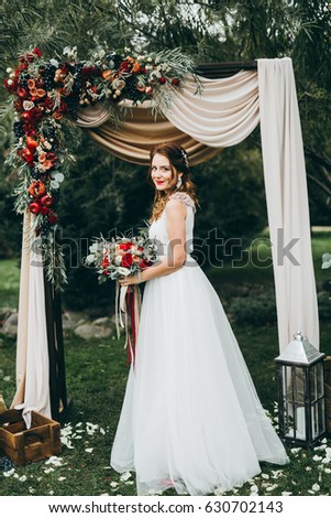 Wonderful bride near arch after wedding ceremony 