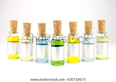 Flowers and plant extracts or perfume in small bottles on white background