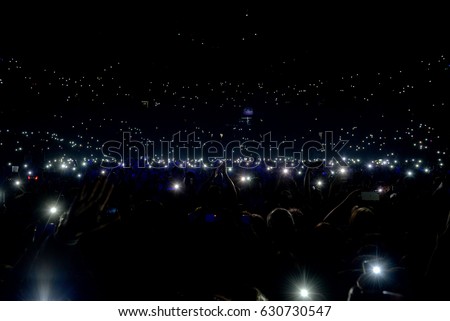 Crowd at concert with lights and camera flash on