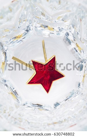 Red star lies in a glass with vodka, close-up concept