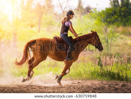 Young pretty girl - riding a horse with backlit leaves behind in spring time 