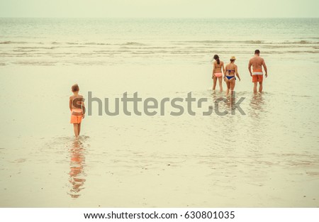 family on the beach and leave a lonely boy behind, unhappy boy, lonely boy, family and emotional concept, vintage photo