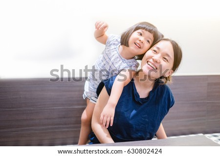 Happy loving family.Asian mother and child girl playing, kissing and hugging