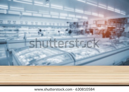 Wood table top on blur supermarket background - can be used for display or montage your products