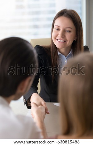 Beautiful friendly real estate agent and client handshaking at office, nice to meet you, businesswoman meeting partners, shaking hands over a table, making deal or partnership, business acquaintance Royalty-Free Stock Photo #630815486