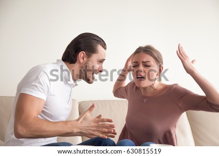 Portrait of angry couple fighting, screaming, shouting and blaming each other for problems, quarrels, negative emotions, difficulties in relationships, misunderstanding in marriage, it is your fault Royalty-Free Stock Photo #630815519
