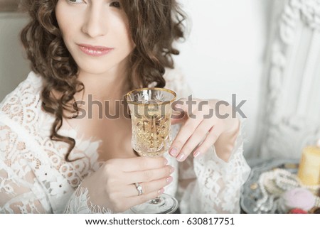 Girl holding a glass close-up with one hand.