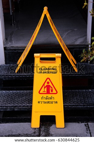 Yellow plastic warning sign "Cleaning" placed in the bathroom entrance.