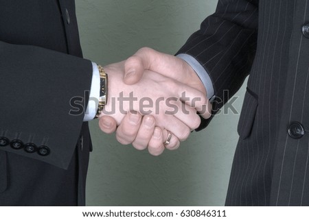 Two businessman in suits shaking hand