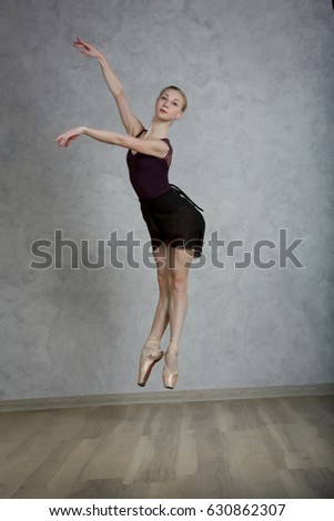 Ballerina in black dress in the studio grey background